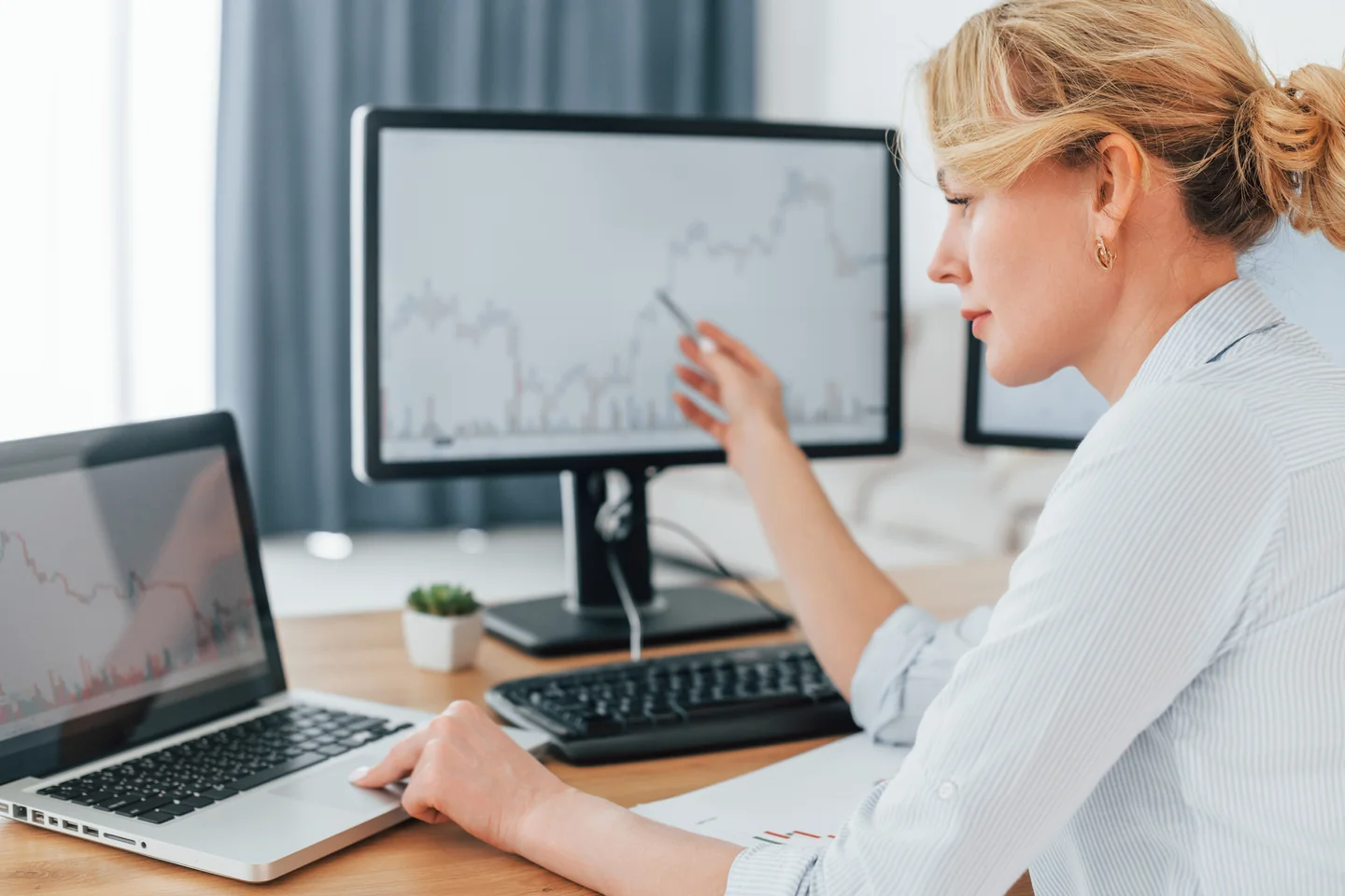 A professional reviewing business charts at a desk.